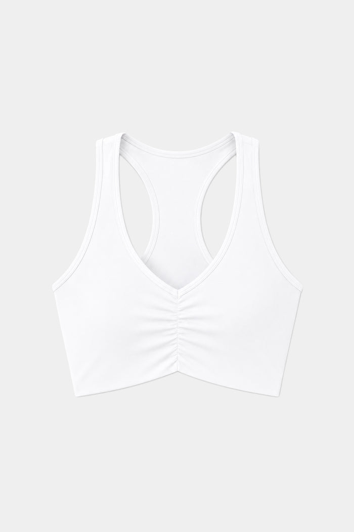 The SPLITS59 Airweight Bra with Ruching in white, made from lightweight performance fabric ideal for hot yoga, is shown against a plain light gray background.