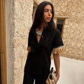 Black Raffia Shirt with fringed short sleeves and shell buttons, styled with a shell necklace.