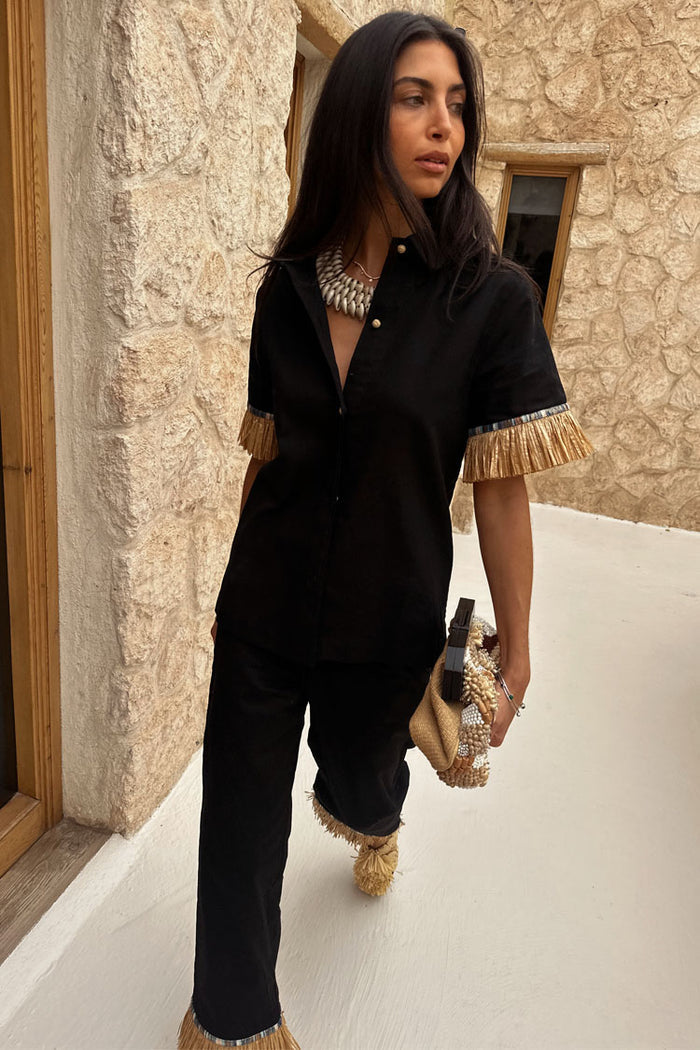 Black Raffia Shirt with fringed sleeves and shell buttons, styled with the matching co-ord trousers.