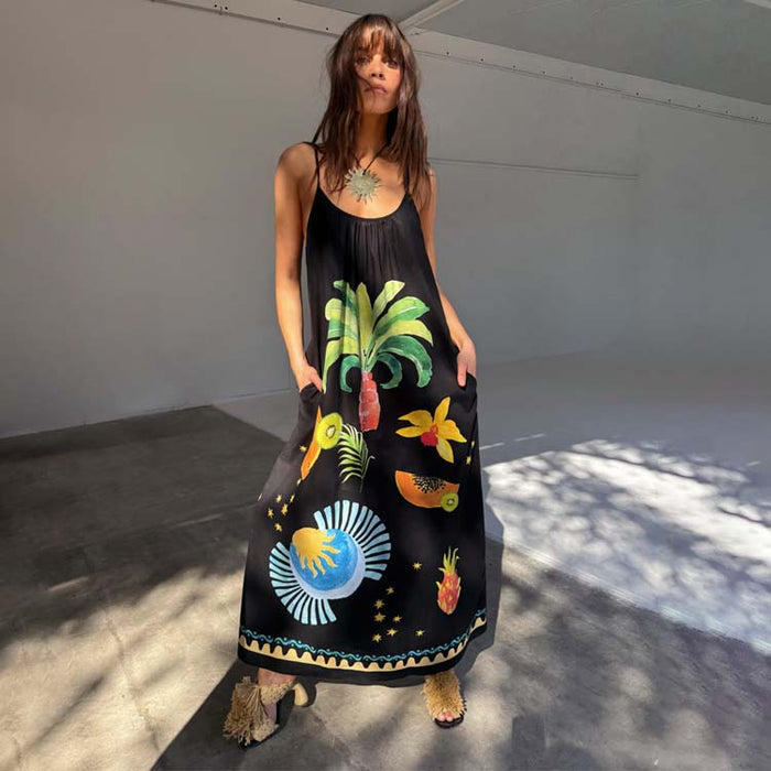 Black Rio Maxi Dress featuring hand-painted tropical fruit motifs, adjustable straps and side pockets, designed in-house.