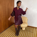Burgundy Mini Kilt Skirt in vegan leather with side buckles and pleated details, styled as a monochrome look.