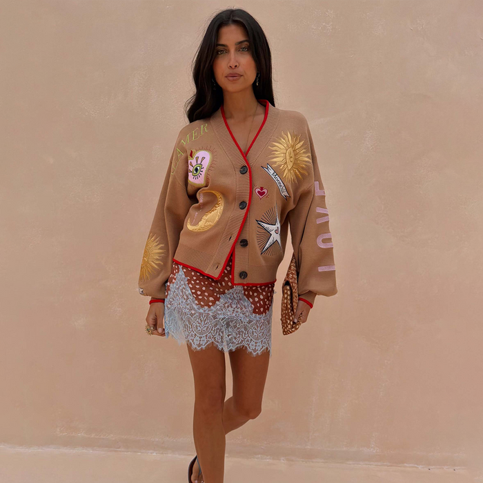 Camel Mystical Cardigan featuring sun and moon embroidery and red ribbed trim, worn by a model.