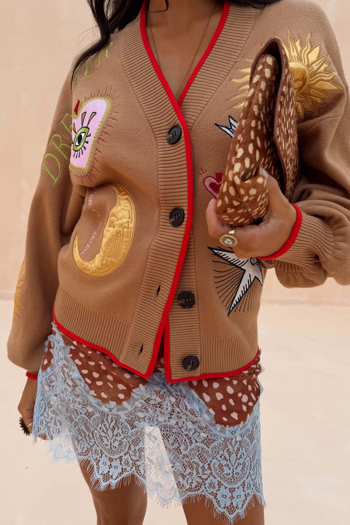 Camel Mystical Cardigan with sun, moon and star embroidery and red trim, styled with a leopard print clutch.