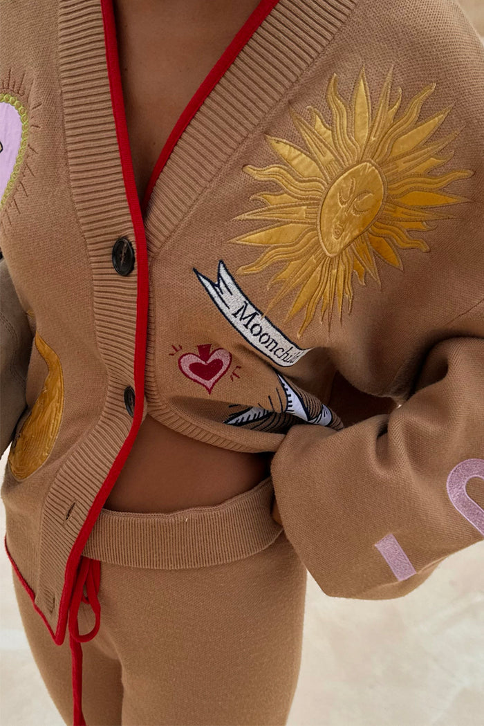 Camel knit co-ord featuring the Mystical Cardigan with sun embroidery and red trim, paired with matching joggers.