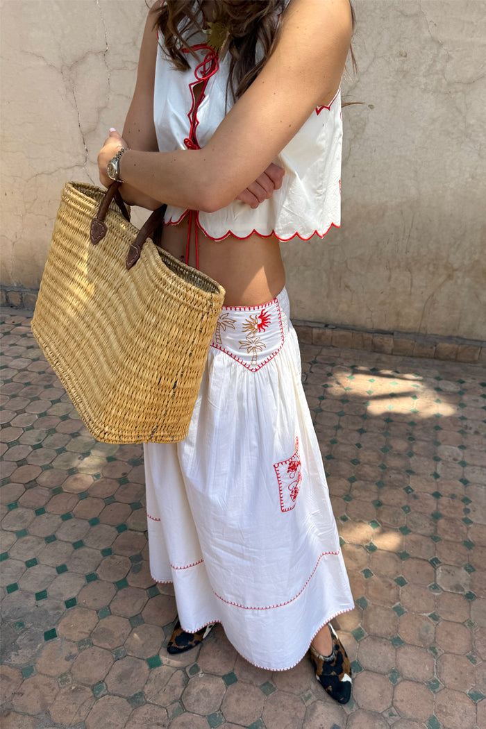 Cream Pollenca Skirt in cotton with red embroidered sun and palm motifs, styled as a vacation-ready co-ord set.