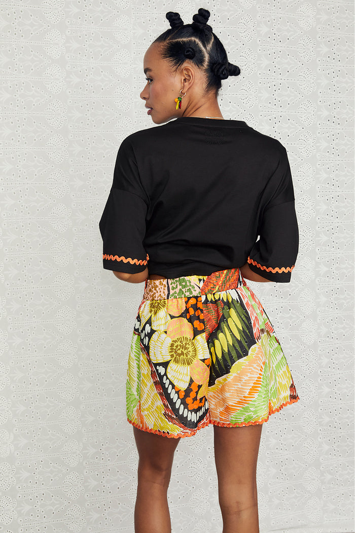 Fiji Elissa Shorts featuring a multi-coloured print and orange rick rack trim, seen from the back.