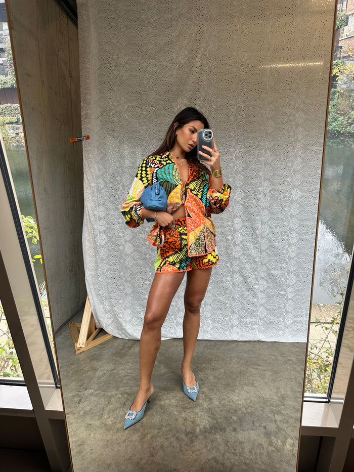 Fiji Elissa Shorts in a multi-coloured print with orange rick rack trim, styled as a co-ord in a mirror selfie.