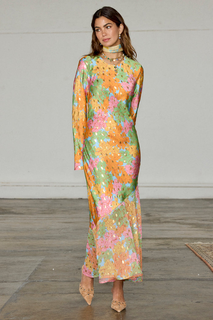 Floral Alaia Dress in a multicoloured print with gold flecks, bell sleeves and an asymmetric skirt.
