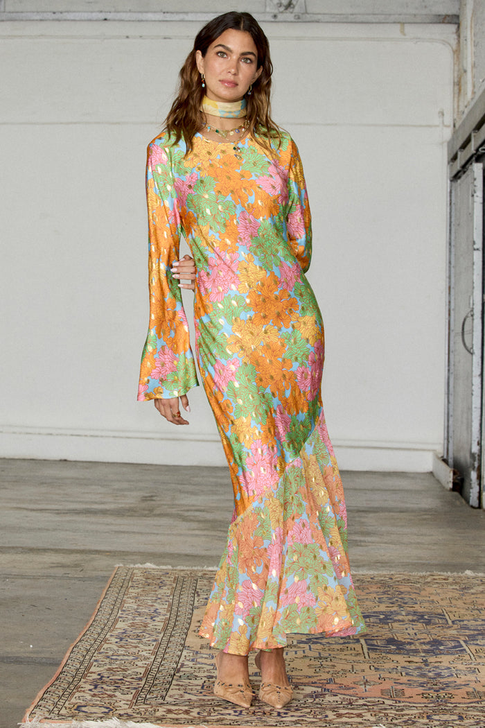 Floral Alaia Dress featuring a multicoloured floral print with gold flecks, bell sleeves and a sheer asymmetric skirt.