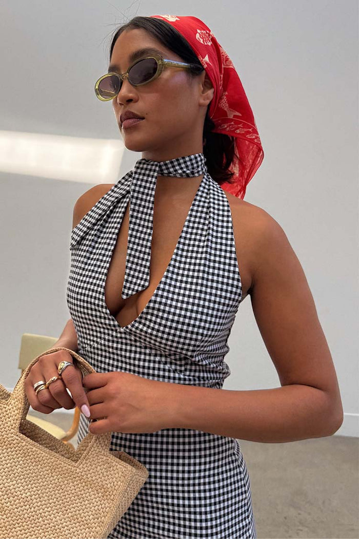 Gingham Halterneck Dress in a monochrome check with a retro tie-neck, styled with a red bandana and straw bag.