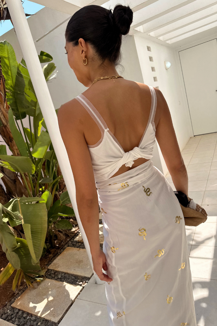 White Gold Snake Jaspre Wrap Skirt featuring gold foil motifs, styled for a multi-wear vacation look.