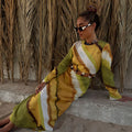 Green Ombre Alba Dress featuring waist cut-outs and gem stone detailing, styled against a palm leaf backdrop.