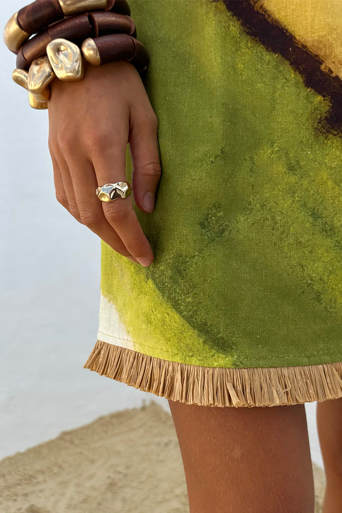 Green Ombre Deia Dress hem detail with a textured raffia trim and earthy green and yellow tones.