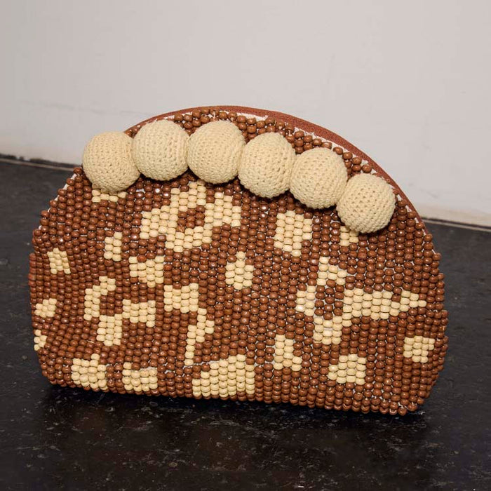 Jaden Beaded Clutch Bag featuring brown and cream patterned beads and statement cream crochet pom-poms.
