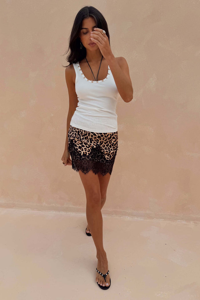 Leopard Lace Mini Maeva Skirt with a black lace hem, paired with a white studded vest top on a model.