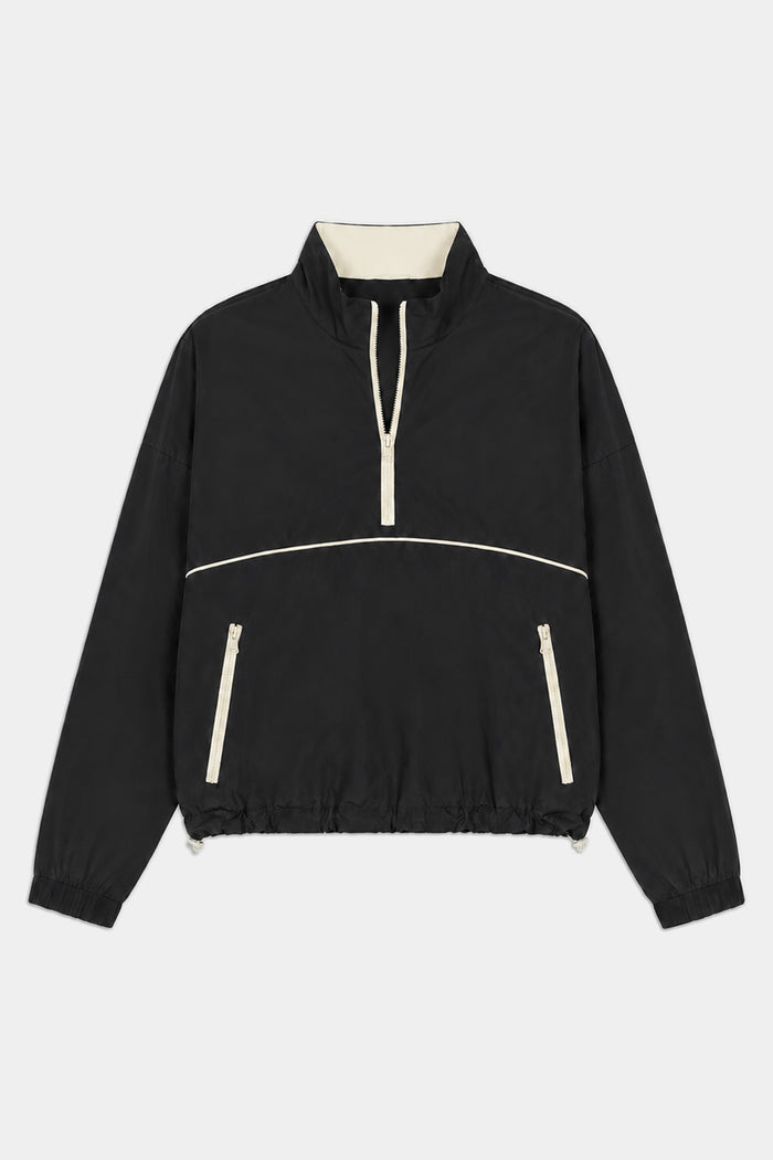 The SPLITS59 Lyle Woven Nylon Pullover in Black/Creme features a half-zip front, stand-up collar, cream trim, two zippered pockets, and elastic cuffs. Made from nylon with a hint of spandex for comfort and flexibility.