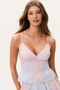 Woman wearing a pastel matching tank top and mini skirt with a white background