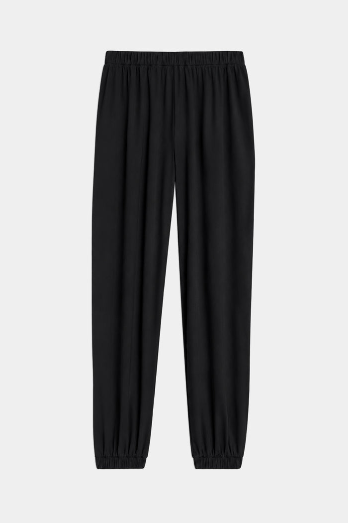 The SPLITS59 Megan Woven Nylon Jogger in black features a lightweight design with a cinched waistband and elastic cuffs, shown laid flat on a light background.