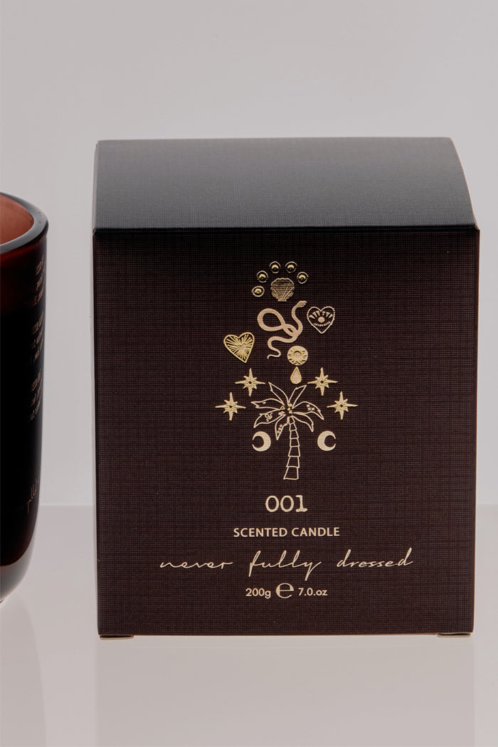 NFD Eau De Parfum Candle 001 packaging in dark brown featuring gold foil palm tree and celestial illustrations.