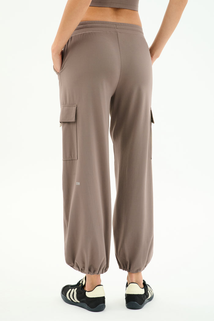 Person wearing SPLITS59 Nico Airweight Cargo Pant in Lentil and black sneakers, shown from the back against a white background—a lightweight, versatile option ideal for workouts.