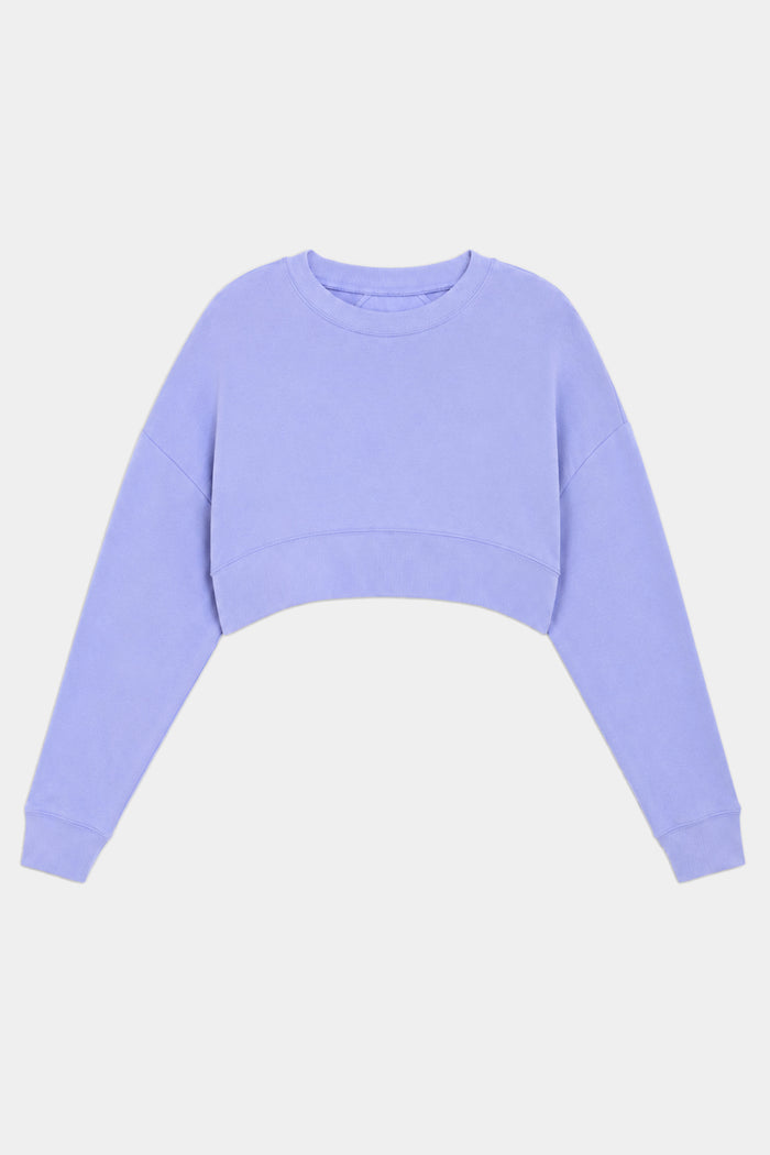 The SPLITS59 Noah Fleece Crop Sweatshirt in Purple Haze is a long-sleeve, crew neck, lavender cropped top made from a stretchy spandex blend, shown against a plain white background.