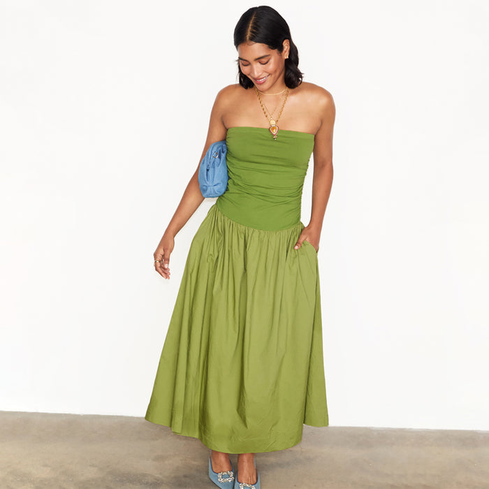 Olive Lola Mid-axi Dress featuring a ruched bandeau bodice and cotton skirt, styled with a blue clutch.