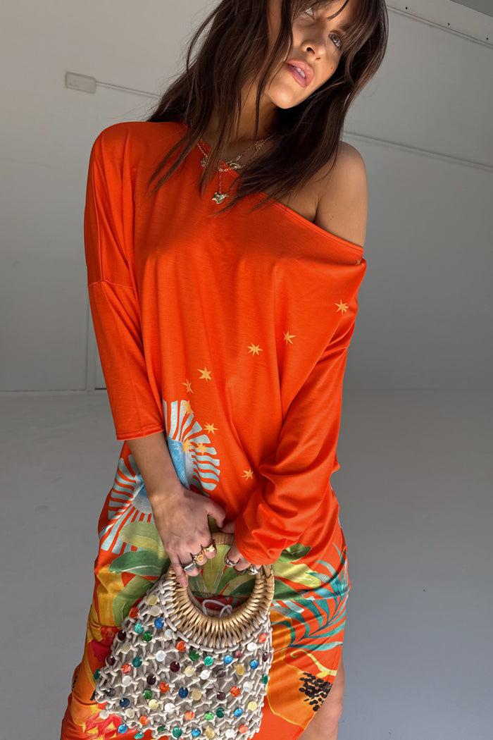 Orange Rio Jem Dress featuring a sun and star print in a relaxed, drop-shoulder silhouette.