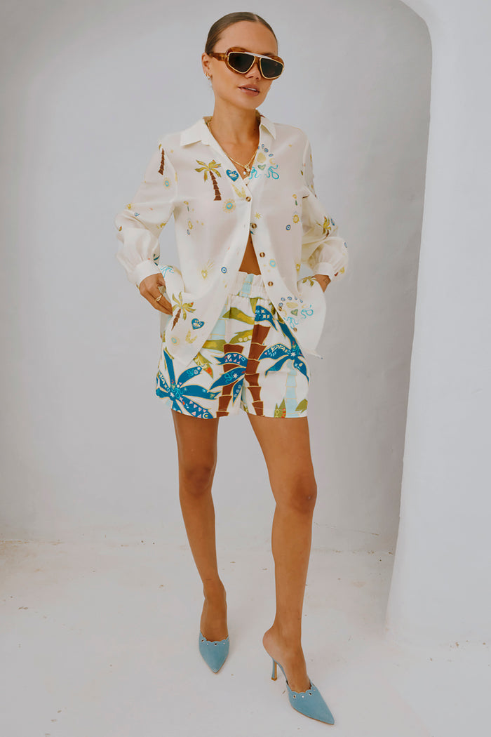Palm Elissa Shorts in a multi-coloured palm leaf print with an elasticated waistband, styled with a matching shirt.
