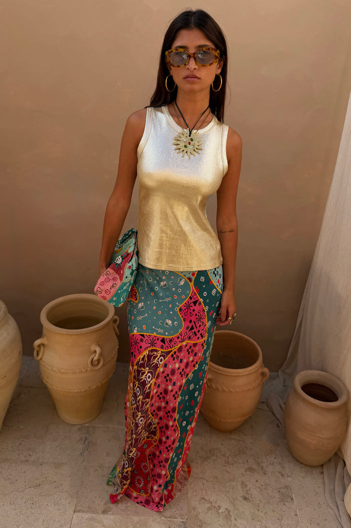 Pastel Morocco Dorris Skirt in an abstract multi print, styled with a metallic gold vest and clay pot backdrop.