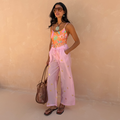 Pink Elissa Trousers featuring gold foil sun motifs, a wide-leg fit and elasticated waist, styled for a vacation look.