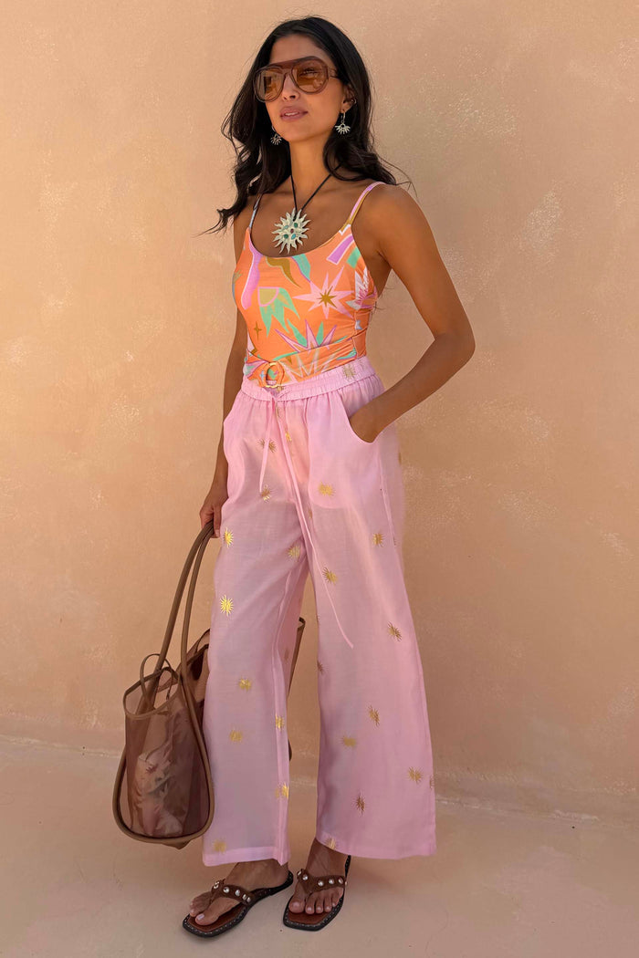 Pink Elissa Trousers with gold sun foil, featuring a wide-leg fit and elasticated waist for a vacation look.