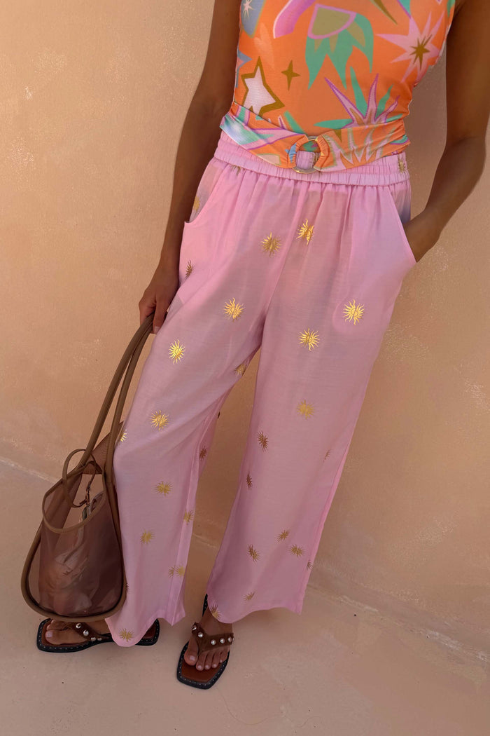 Pink Elissa Trousers featuring gold sun foil motifs, a wide-leg fit and elasticated waistband.