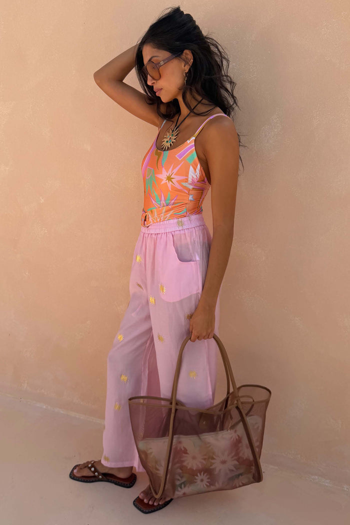 Pink Elissa Trousers featuring gold sun foil motifs and a wide-leg fit, styled for a vacation look.