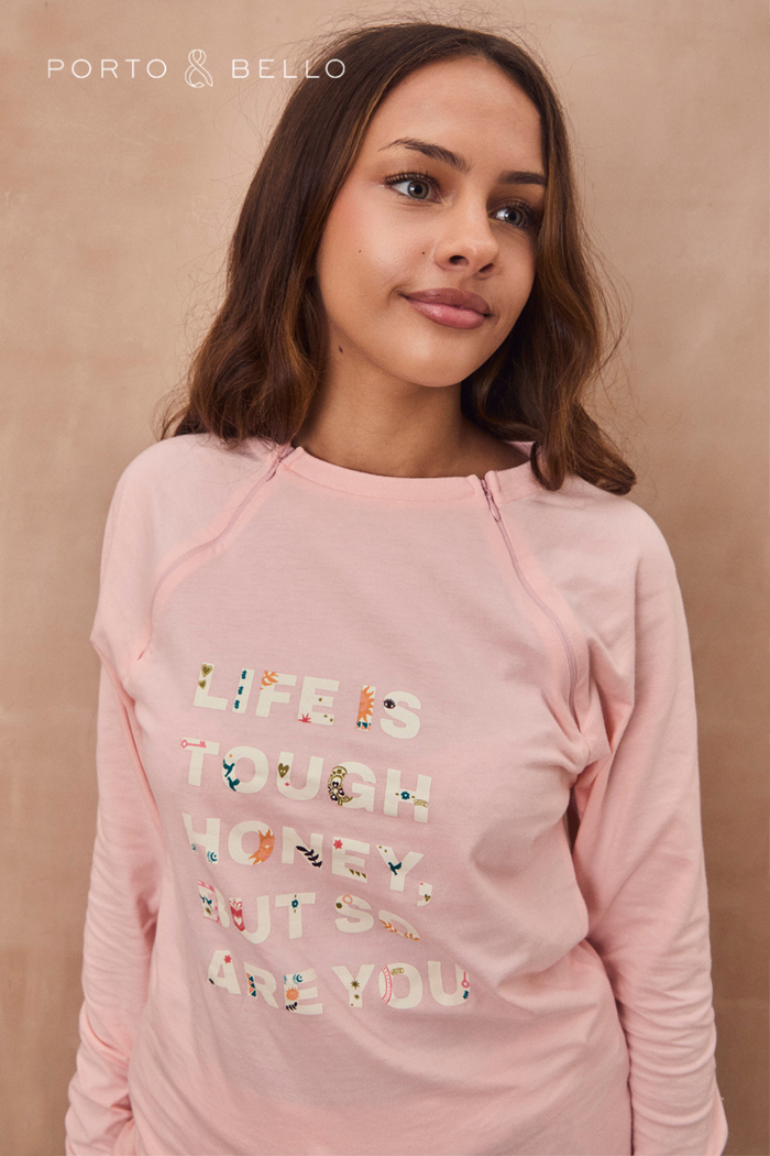 Pink long sleeve accessible t-shirt with Life is Tough lettering and concealed treatment zips on a model.