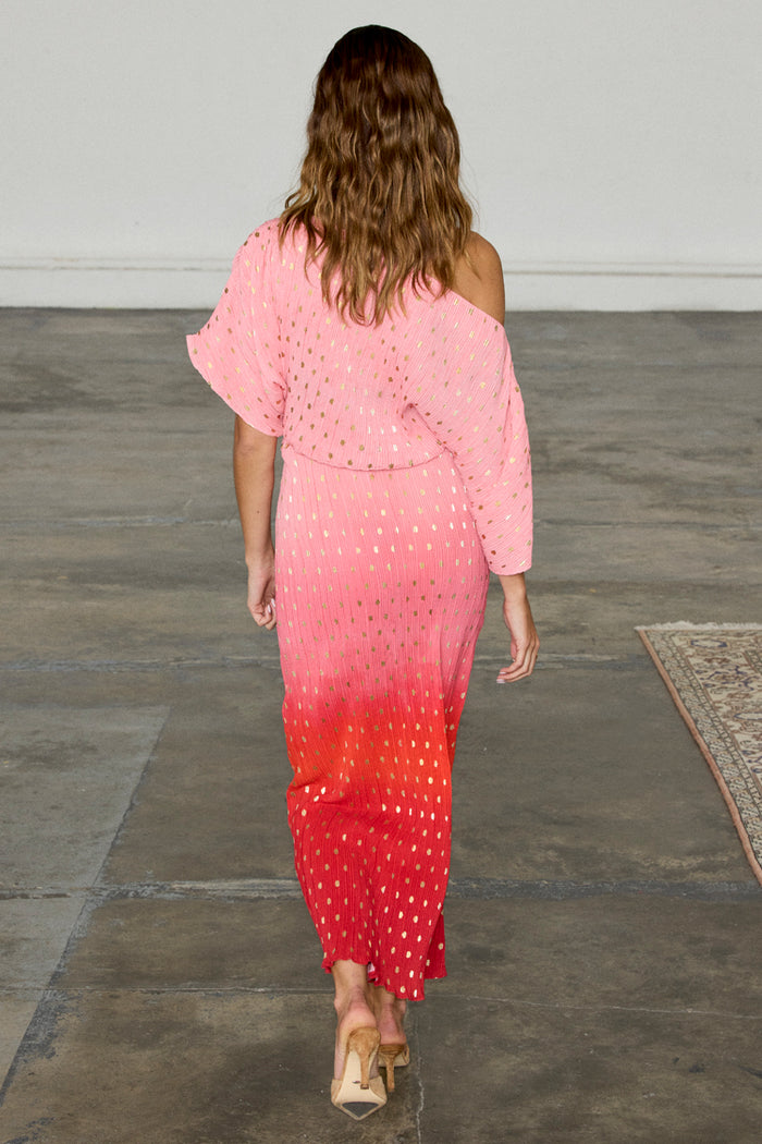 Pink and red ombre Tilly Dress in gold shimmer plisse with a draped asymmetric neckline, shown from the back.