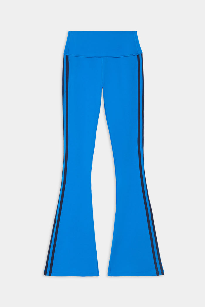 Raquel High Waist Supplex Flare pants by SPLITS59 in Classic Blue/Indigo, featuring a high waist and black vertical side stripes, displayed flat on a white background.