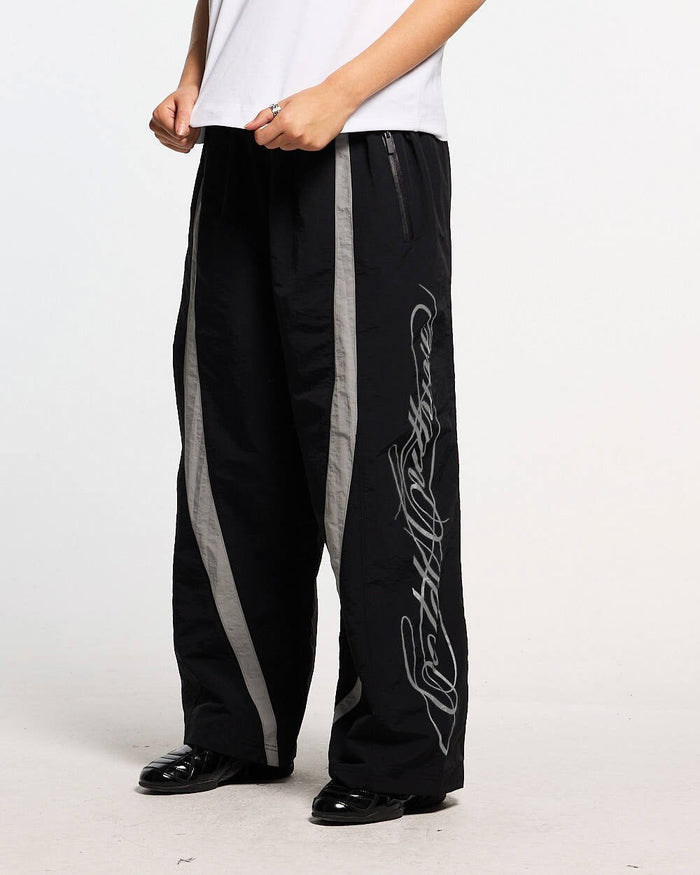 SCRIPT TECH PANTS BLACK - black script print sweatpants, front view on male model - Cold Culture #man