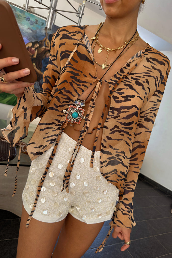 Cream beaded Shells Hot Pants with pearlescent shell details, styled with a sheer tiger print tie-front top.