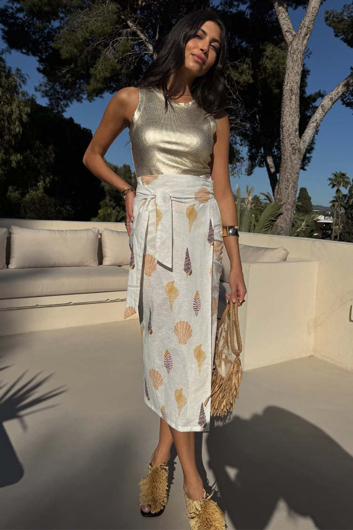 Shells Jaspre Wrap Skirt with a seashell print and multi-wear tie, styled with a gold top for vacation.