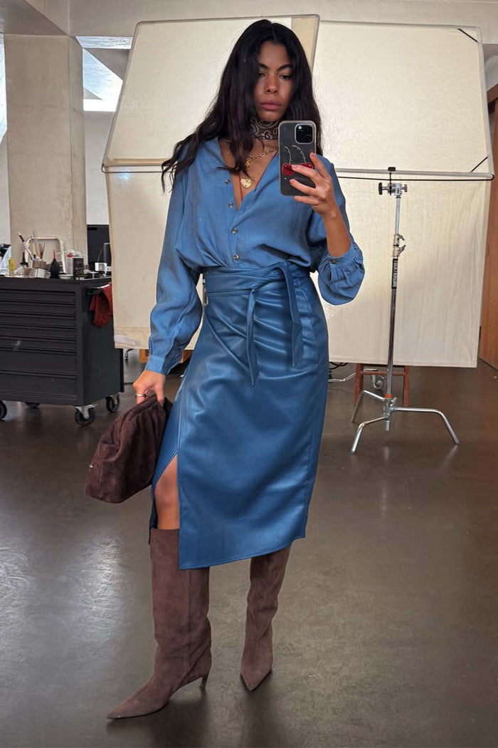 Teal Vegan Leather Jaspre wrap skirt styled with a matching blouse and brown boots in a studio mirror selfie.