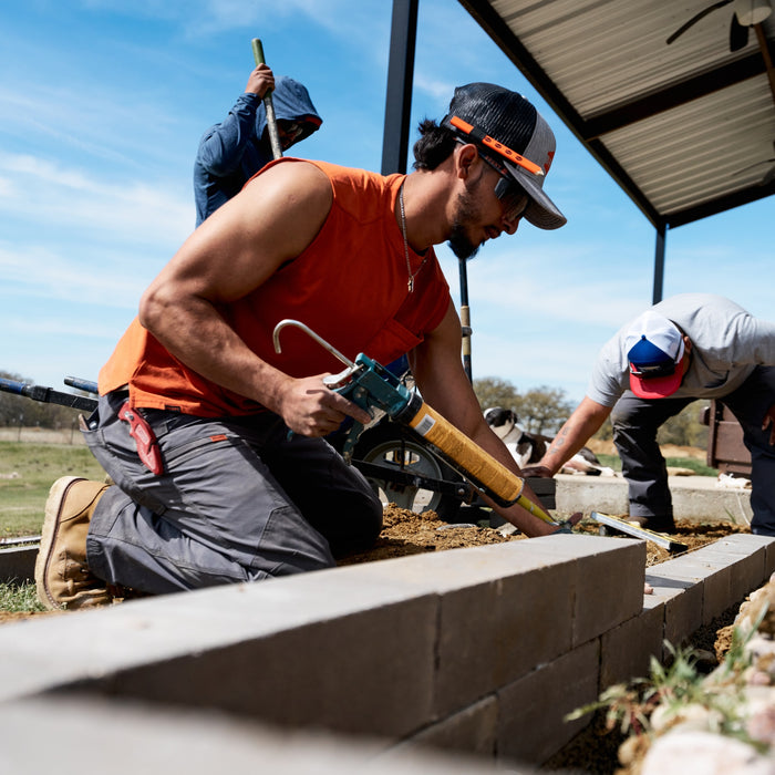 Man on jobsite wearing BRUNT comfortable sleeveless pocket tee in BRUNT orange