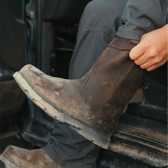 Man pulling on BRUNT 10 inch waterproof composite toe pull-on work boot in dark brown