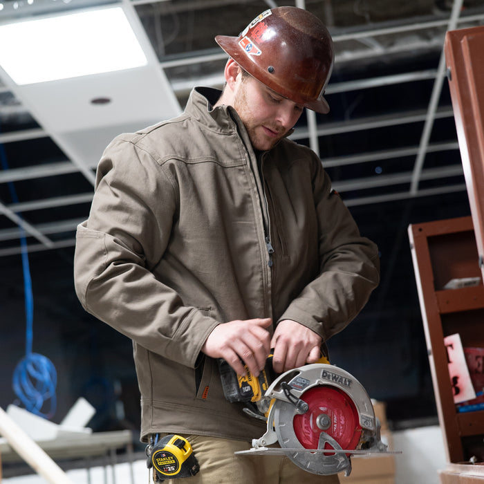 Man wearing BRUNT utility scott jacket in brown using circle saw on jobsite * 0