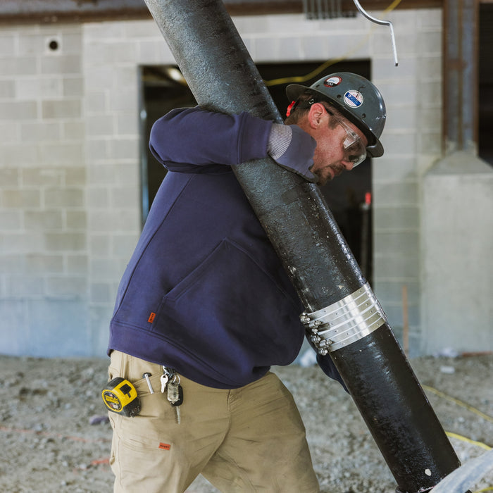 Man on jobsite wearing the BRUNT water resistant midweight crewneck in navy blue