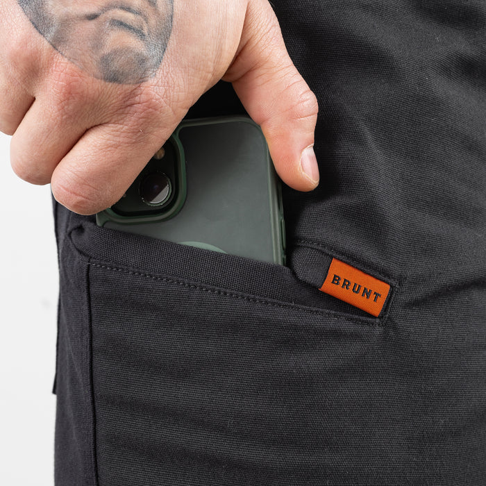 Putting phone in pocket of the BRUNT 9 inch water resistant stretch work short in black