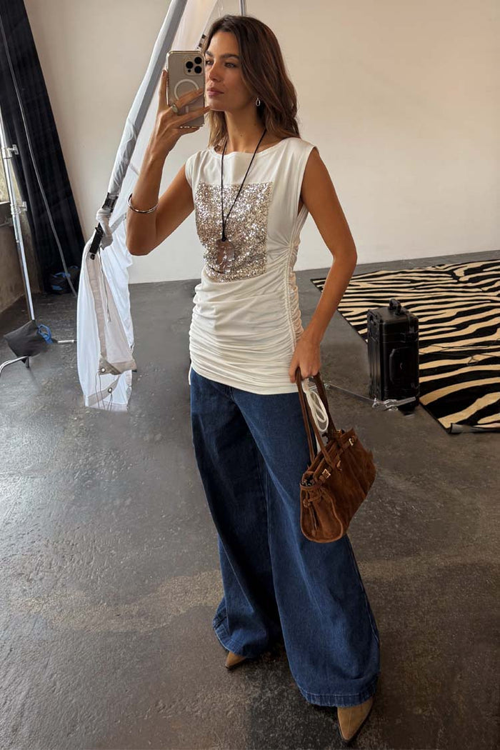White Sequin Ruched Dress featuring a silver sequin panel and adjustable side ruching, styled over wide-leg denim.
